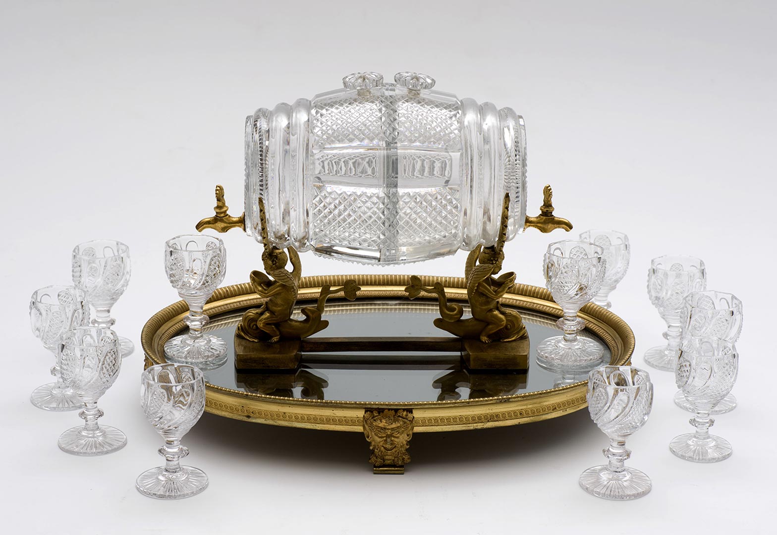Cristallerie de Vonêche (1802 – 1830) Tonnelet double à liqueur et son plateau en cristal taillé et bronze doré, mention "À l'Escalier de Cristal/Médaille d'or 1819", 19 cm x 26 cm x Ø 13 cm et 5,4 cm x 33,8 cm x 24,3 cm. (Verrerie)