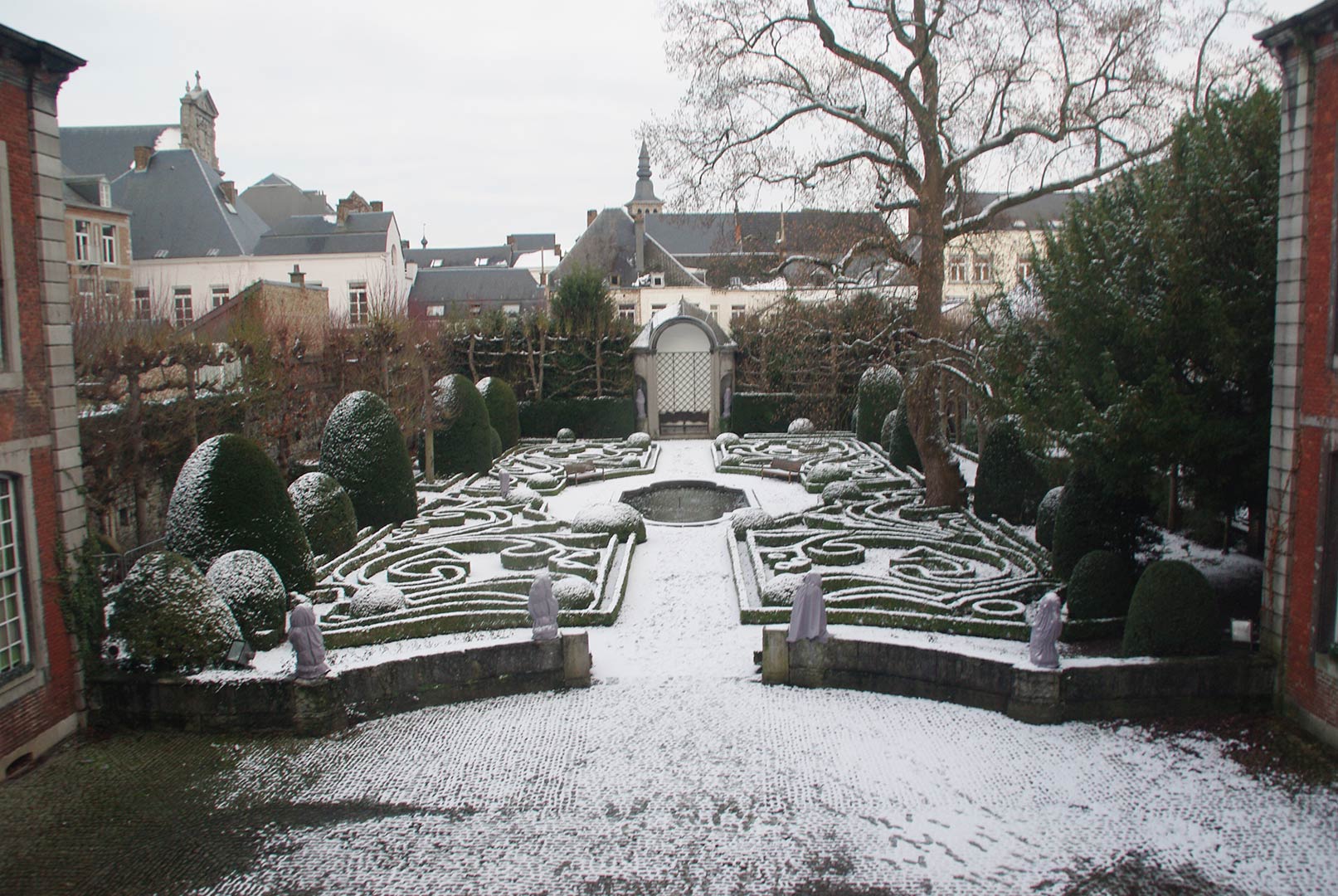 Le jardin en hiver permet d'observer le dessin fait d'arabesques asymétriques en buis taillés conçu par Hector Mathieu en 1937. Dans le fond à droite, se cache l'orangerie.