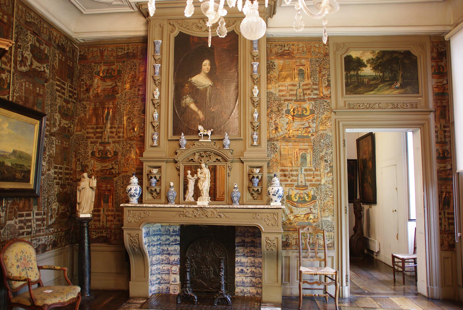 Cette salle a les murs recouverts de cuirs gaufrés et dorés réalisés dans nos régions vers 1700. La cheminée, dans le style de Daniel Marot, est décorée de potiches en Delft.