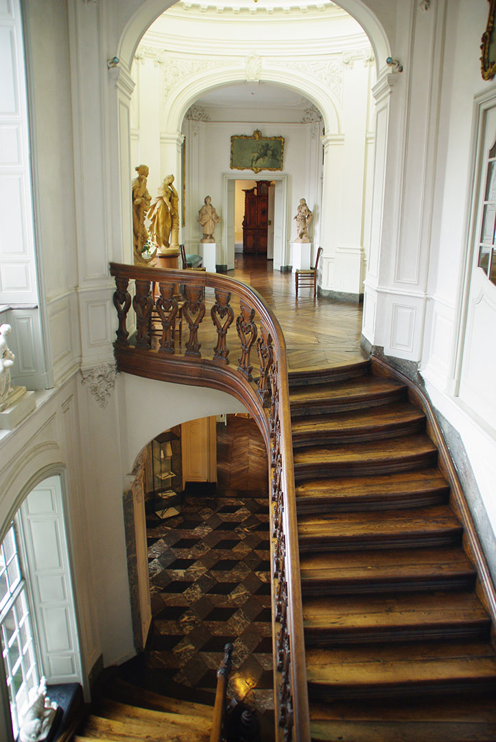 Vue générale de l'escalier d'honneur aux proportions élégantes. Les fuseaux sont ajourés avec des coquilles rocailles.